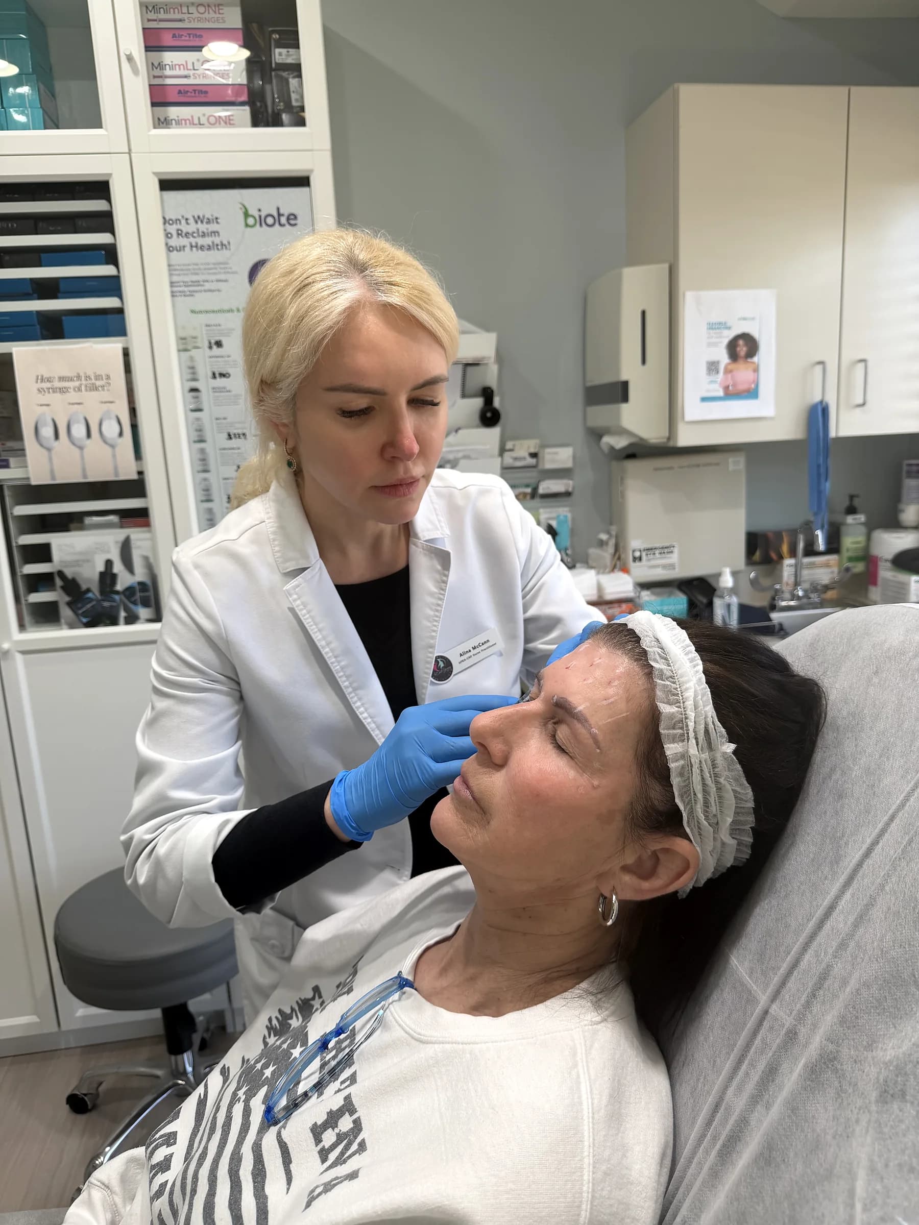 Alina McCann treating a patient's forehead