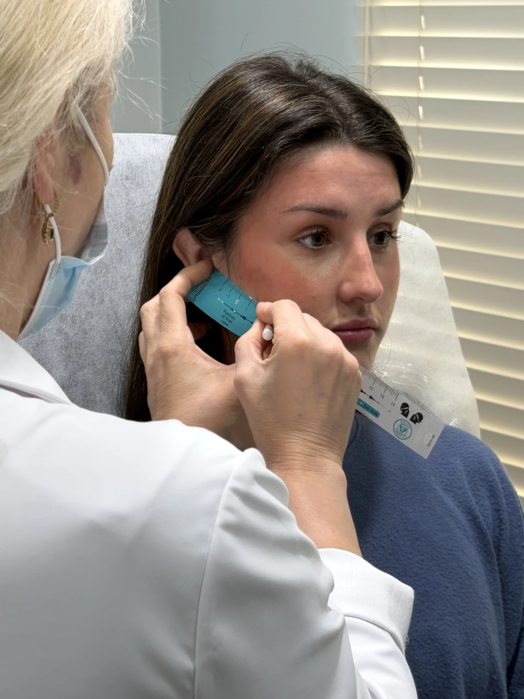 Alina McCann showing a patient the filler she will use
