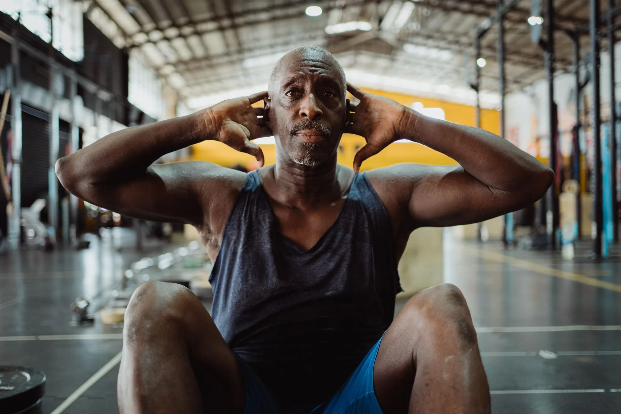 Focused mature man performing sit-ups in a gym. Fitness and determination.
