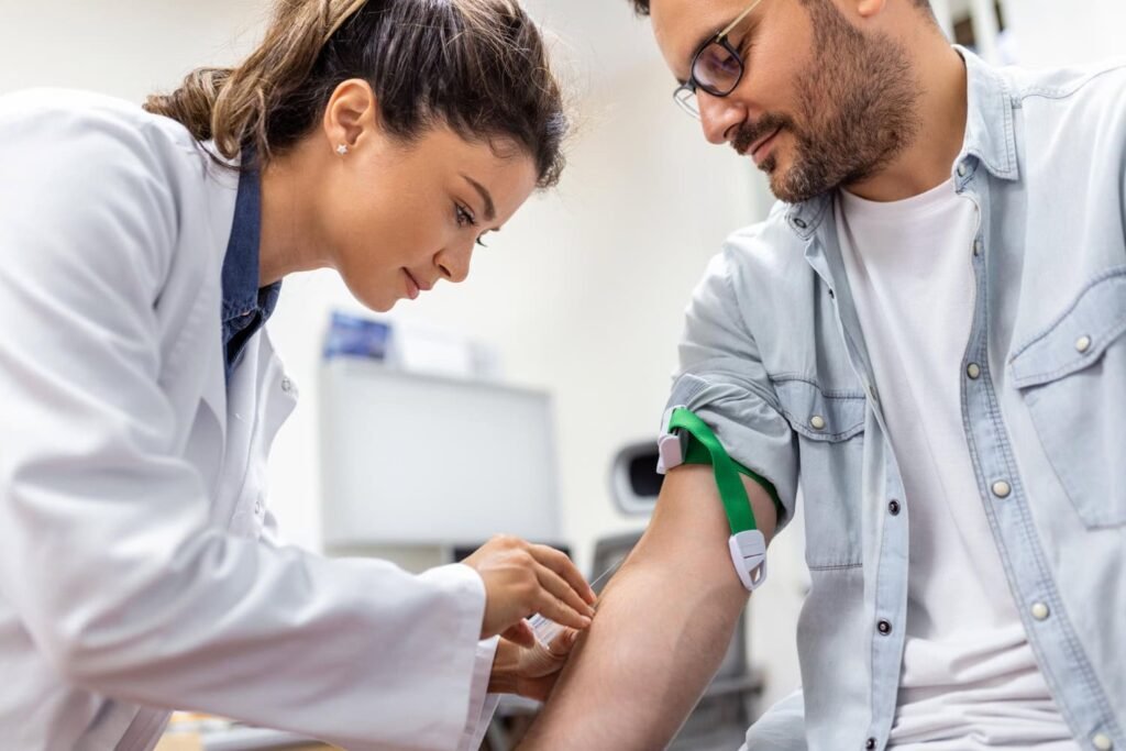 Man receiving a blood test from a healthcare professional, focusing on men's health and wellness checks at 4Ever Young STL MedSpa.